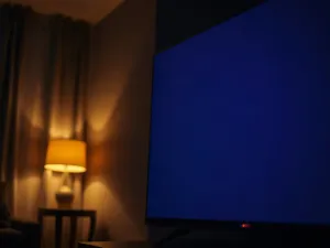 Ekran smartfona z widocznym menu ustawień uprawnień aplikacji na tle minimalistycznego biurka.